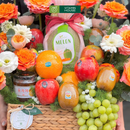 giỏ quà tặng trái cây nho xanh, kiwi, dưa lưới và trà mật ong cao cấp trang trí cùng hoa tươi tone cam. Món quà dành cho ngày đặc biệt