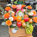 giỏ quà tặng trái cây nho xanh, kiwi, dưa lưới và trà mật ong cao cấp trang trí cùng hoa tươi tone cam. Món quà dành cho ngày đặc biệt