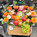 giỏ quà tặng trái cây nho xanh, kiwi, dưa lưới và trà mật ong cao cấp trang trí cùng hoa tươi tone cam. Món quà dành cho ngày đặc biệt