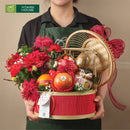 Hình ảnh giỏ quà cao cấp kết hợp hoa tươi, trái cây nhập khẩu trong làn tre đỏ trang nhã chụp hình cùng người