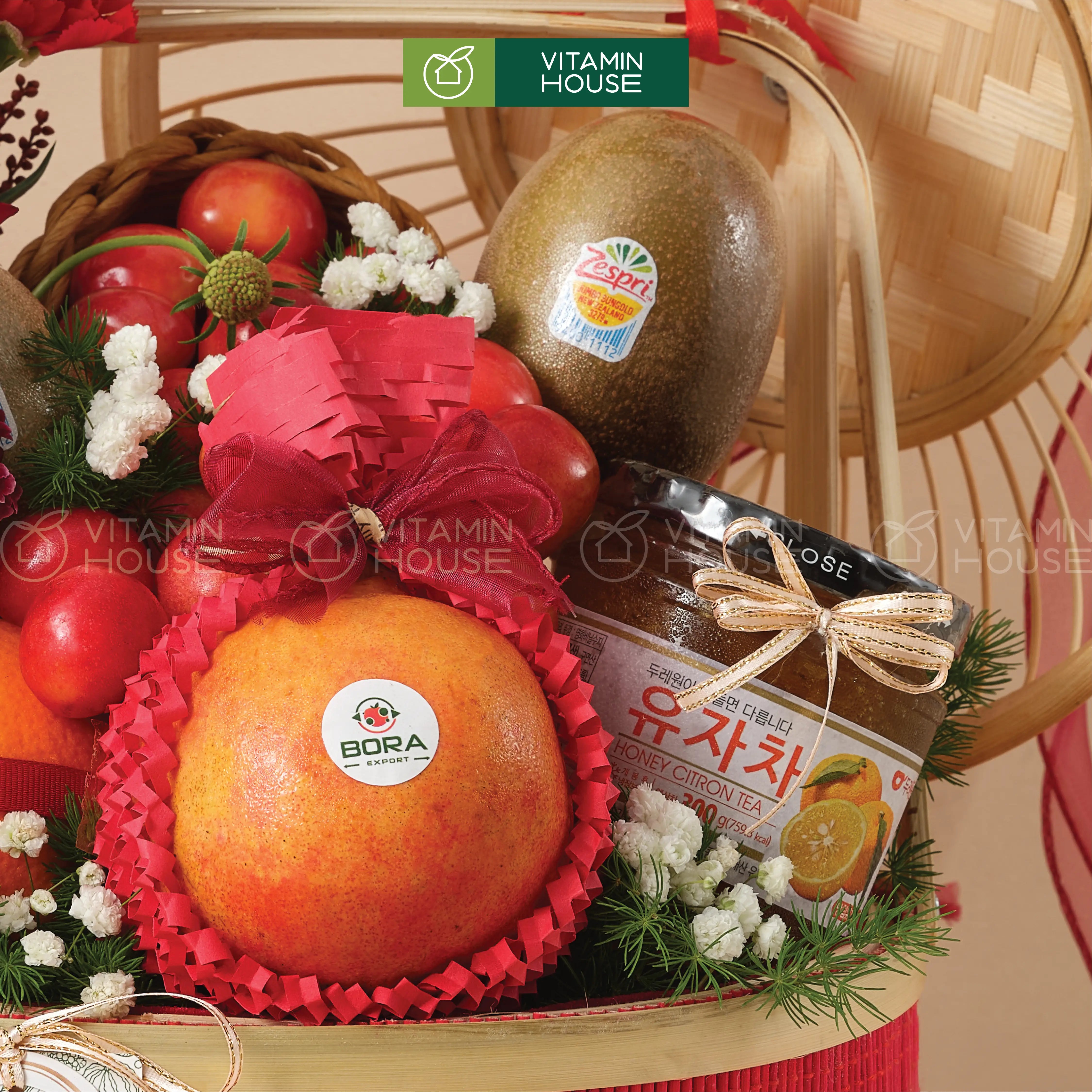 Hình ảnh cận cảnh giỏ trái cây sang trọng với hoa đỏ và trái cây nhập khẩu thanh yên mật ong Hàn Quốc